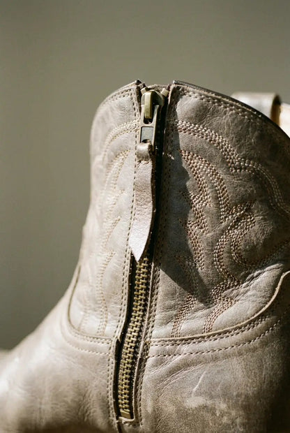 Close-up of pointed toe and side zip on taupe boot