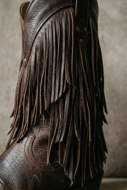 Close-up of layered fringe and block heel on cognac boot